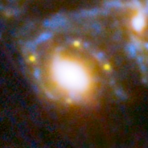 Autour d'une galaxie géante faisant office de lentille, quatre points lumineux, de couleur jaune. Ce sont les quatre images d'une supernova située à 9.3 milliards d'années-lumière. La lumière de la supernova est amplifiée vingt fois. Cette observation exceptionnelle, en plus de prouver une nouvelle fois la validité de la théorie de la relativité générale d'Einstein, va permettre aux cosmologistes d'étudier la matière noire et l'énergie sombre. Photo Nasa/STSCI.