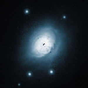 Sur cette image prise par le télescope spatial Hubble, le disque de gaz et de poussières qui entoure l'étoile HD 100546 s'étend sur des dizaines de milliards de kilomètres. L'étoile, au centre de l'image, est cachée par le masque du coronographe qui équipe le télescope spatial. Photo Nasa/ESA/STSCI.