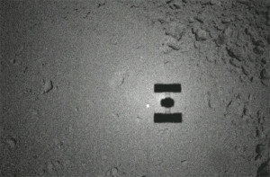 En novembre 2005, Hayabusa a pris cette image de sa propre ombre se découpant sur l'astéroïde Itokawa. L'un des nombreux épisodes de la spectaculaire aventure du courageux petit robot japonais. Photo Jaxa.