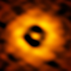 Zoom au coeur du disque de TW Hydrae. Autour de l'étoile, au centre de l'image et invisible à cette longueur d'onde, une division sombre, à la même distance que la distance Soleil-Terre. Dans ce sillon creusé dans le disque, une autre Terre est-elle entrain de naître ? Photo ESO/NRAO/NAOJ.