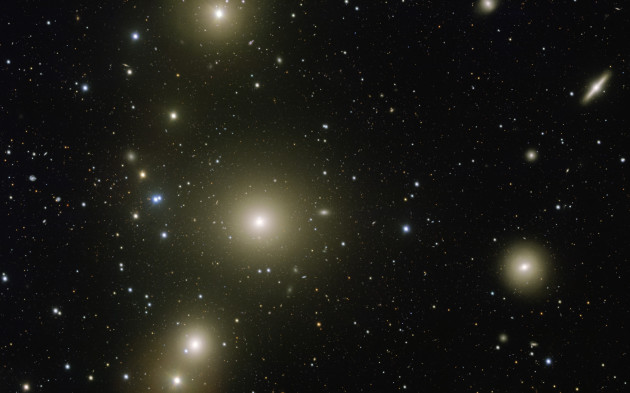 Au cœur de l'amas Fornax trône la galaxie géante NGC 1399. Cet amas de galaxies se trouve à 65 millions d'années-lumière de la Voie lactée. L'influence gravitationnelle de la galaxie géante sur ses voisines est énorme : un pont d'étoiles, invisible sur cette image, relie déjà la petite galaxie NGC 1387, à droite de l'image, à la galaxie géante. A terme, NGC 1399 absorbera complètement sa compagne. Photo ESO.