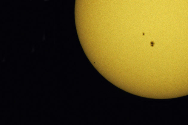 Exactement au centre de l'image, apparaît le disque minuscule de la planète Mercure en transit devant le Soleil. A droite, des taches solaires sont visibles. Photo S.Brunier.
